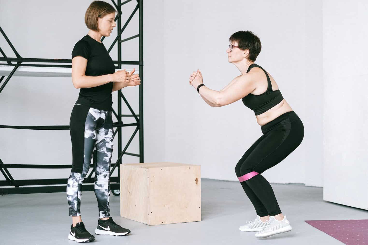 a woman supervising an elderly woman exercise