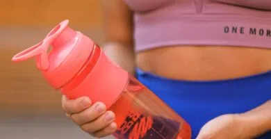 Nutrición para corredores mayores de 40 años 1 crop faceless sportswoman standing with reusable water bottle