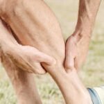 man massaging his calf muscles